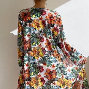 Femme portant une blouse légère à motifs floraux colorés, parfaite pour l'été et les journées ensoleillées.