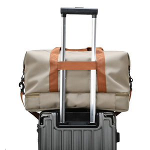 GoHappy France, sac de voyage Escapade Libre beige sable fixé sur la poignée d’une valise, vue du dos
